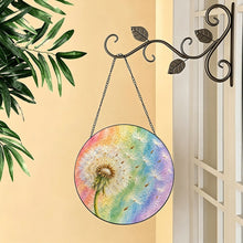 Carica l'immagine nel visualizzatore di Gallery, Wish Come True dandelion glass suncatcher hanging from a decorative metal hook beside a window with greenery and soft natural light.