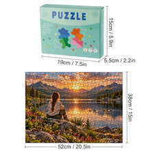 Load image into Gallery viewer, REFLECTIONS 500 piece wooden jigsaw puzzle featuring a woman with a braid sitting on a rock overlooking a glowing mountain lake with wildflowers, ducks, and chipmunks.