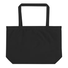 Load image into Gallery viewer, Back view of Green Theory oversized black organic cotton tote bag showing its plain black exterior, spacious shape, flat bottom, and long shoulder straps.