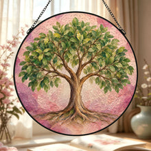 Carica l'immagine nel visualizzatore di Gallery, Close-up of the Rooted in Abundance glass suncatcher displaying a leafy Tree of Life with visible roots and softly blended pink and mauve hues.

