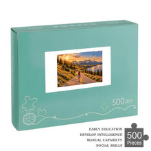 Carica l'immagine nel visualizzatore di Gallery, THE ROAD AHEAD 500 piece wooden jigsaw puzzle featuring a woman walking along a mountain road beside a blue lake with wildflowers, deer, birds, and snow capped peaks.
