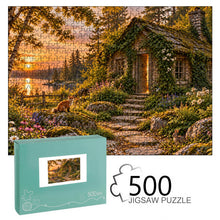 Загрузить изображение в средство просмотра галереи, THE OPEN DOOR 500 piece wooden jigsaw puzzle featuring an abandoned ivy covered cottage with a glowing cracked door, woodland path, sunset lake, fox, rabbit, and wildflowers.
