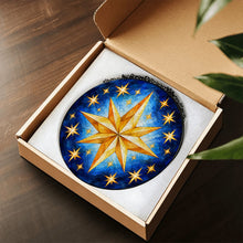 Загрузить изображение в средство просмотра галереи, Written in the Stars stained glass-style suncatcher displayed in an open gift box, featuring a golden eight-point star surrounded by smaller stars.
