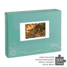 Загрузить изображение в средство просмотра галереи, THE OPEN DOOR 500 piece wooden jigsaw puzzle featuring an abandoned ivy covered cottage with a glowing cracked door, woodland path, sunset lake, fox, rabbit, and wildflowers.
