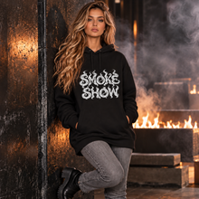 Carregar imagem no visualizador da galeria, Female model posing against a dark wall in a black SMOKE SHOW organic hoodie featuring swirling white smoke typography.
